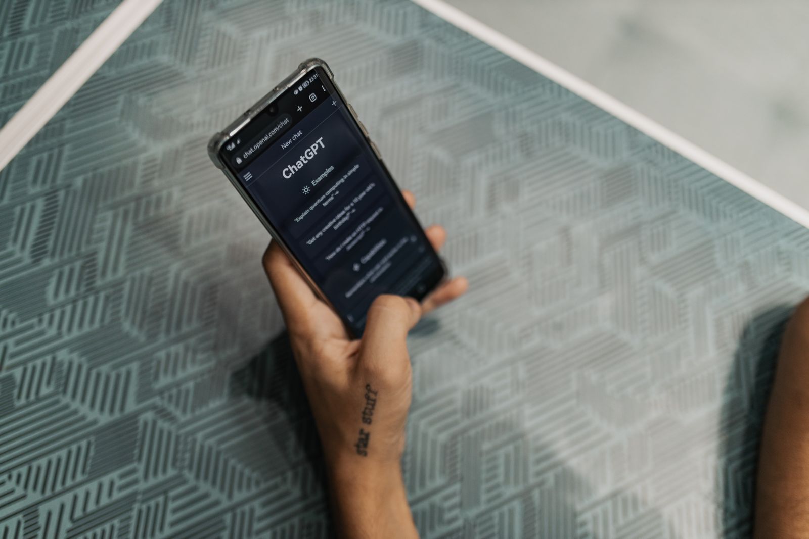 Hand holding a phone open to an AI chat interface